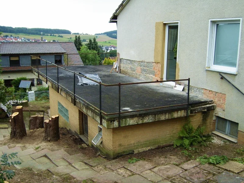 Alter Balkon mit beschädigter Oberfläche und sichtbaren Undichtigkeiten