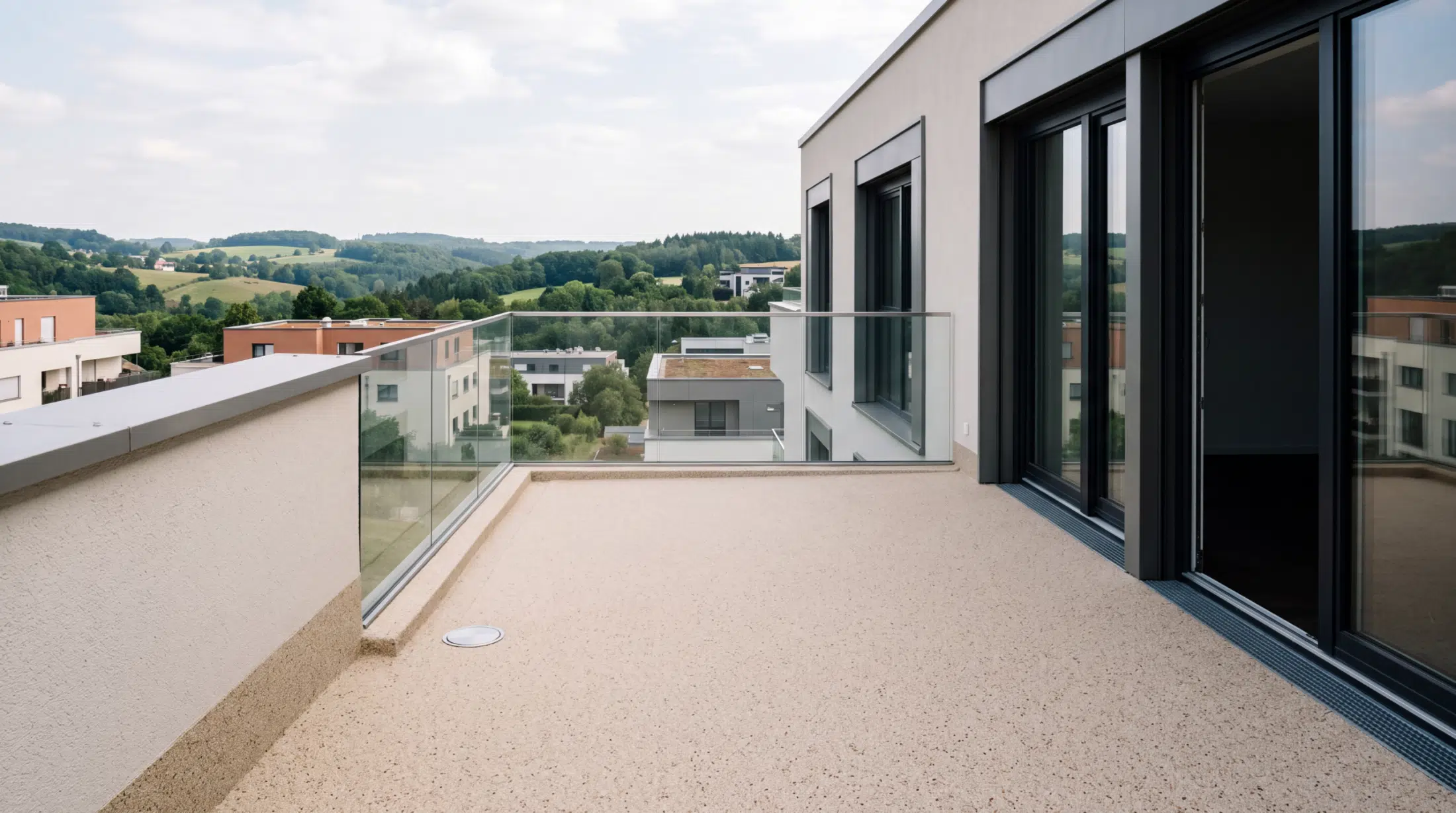 Dachterrasse mit hellem Steinteppich und Glasgeländer