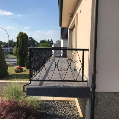 Sanierter Balkon mit dunklem Steinteppich und Metallgeländer