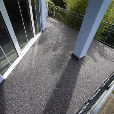 Balkon mit grauem Steinteppich und umlaufendem Metallgeländer
