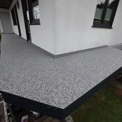 Sanierter Balkon mit grauem Steinteppich