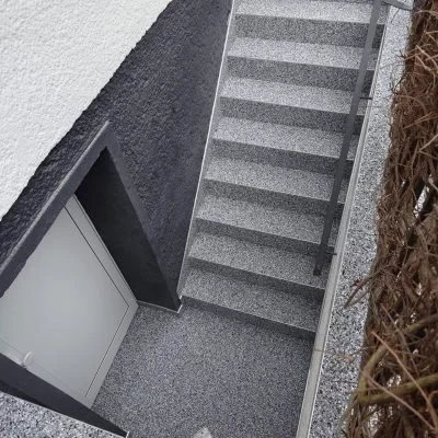 Sanierte Kellertreppe mit grauem Steinteppich