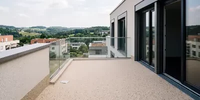 Dachterrasse mit hellem Steinteppich und Glasgeländer