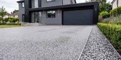 Grauer Steinteppich als befahrbare Einfahrt vor einem Wohnhaus