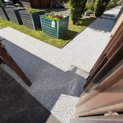 Terrasse mit hellgrauem Steinteppich und angrenzendem Weg