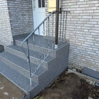 Sanierte Eingangstreppe mit grauem Steinteppich
