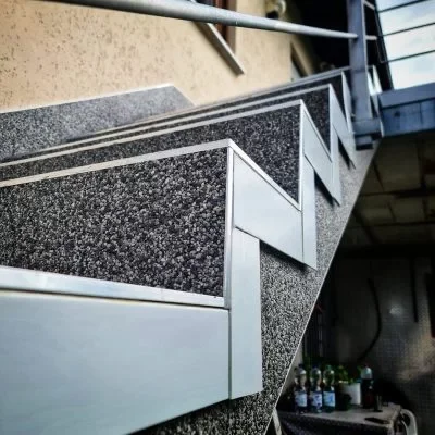 Detail einer sanierten Treppe mit Steinteppich und Metallkanten